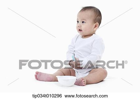 Stock Photograph - a baby with a bowl and a spoon. Fotosearch