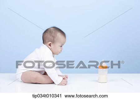 Stock Image - a baby with a milk bottle in front. Fotosearch