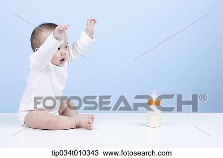 Stock Image - a baby with a milk bottle in front. Fotosearch