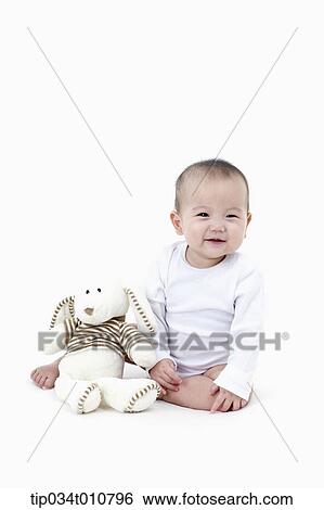Stock Photograph - a baby with a stuffed animal toy. Fotosearch