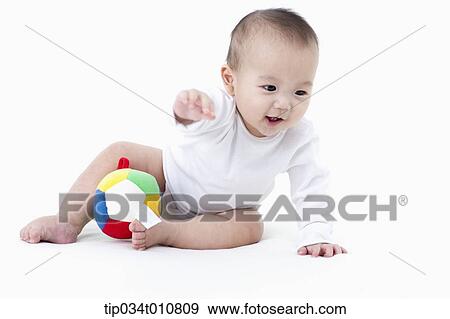 Stock Photo - a baby with a toy ball. Fotosearch