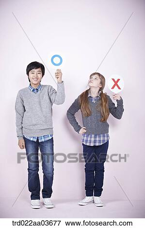 Stock Photo - a boy and a girl each holding boards saying correct and wrong. Fotosearch