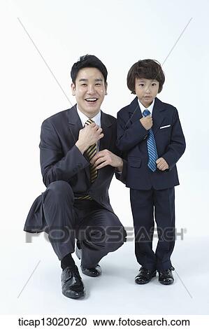 Stock Image - a boy dressed up as a business man with his father. Fotosearch