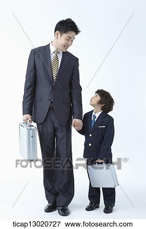 Stock Photo - a boy dressed up as a business man with his father. Fotosearch