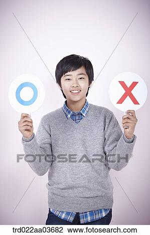 Stock Image - a boy holding boards saying correct and wrong. Fotosearch