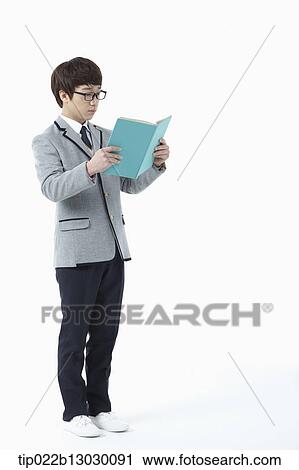 Stock Image - a boy in a school uniform reading a book. Fotosearch