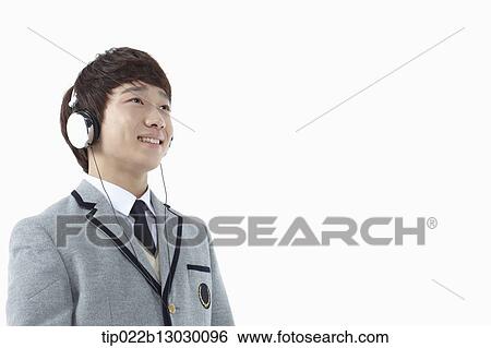 Stock Photograph - a boy in a school uniform wearing a head set. Fotosearch