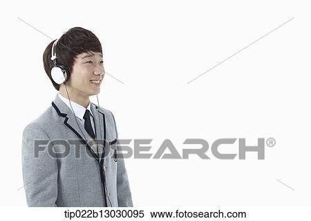 Stock Photography - a boy in a school uniform wearing a head set. Fotosearch