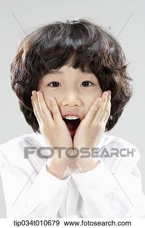 a boy in white shirt looking surprised View Large Photo Image Stock Photo - a boy in white shirt looking surprised. Fotosearch
