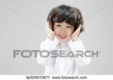 Stock Photo - a boy in white shirt showing his face. Fotosearch