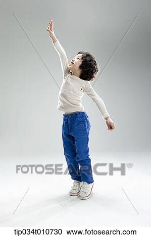 Stock Image - a boy jumping to reach something. Fotosearch