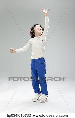 Stock Image - a boy jumping to reach something. Fotosearch