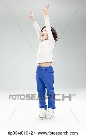 Stock Photo - a boy jumping to reach something. Fotosearch