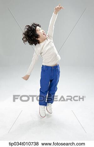 Stock Photo - a boy jumping to reach something. Fotosearch