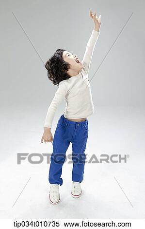 a boy jumping to reach something View Large Photo Image Stock Photography - a boy jumping to reach something. Fotosearch