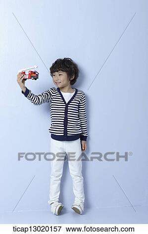 a boy playing with a fire truck View Large Photo Image Stock Photo - a boy playing with a fire truck. Fotosearch