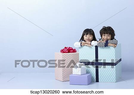 Stock Image - a brother and a sister inside a present. Fotosearch
