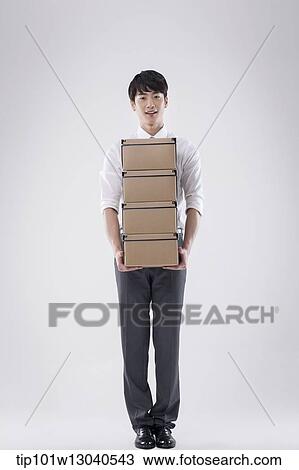 a business man carrying a pile of boxes View Large Photo Image Stock Image - a business man carrying a pile of boxes. Fotosearch