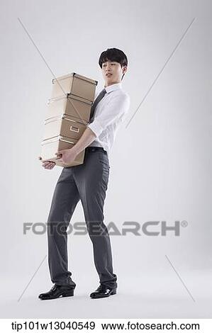 Stock Photo - a business man carrying a pile of boxes. Fotosearch