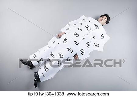 Stock Photo - a business man covered by papers that say no. Fotosearch