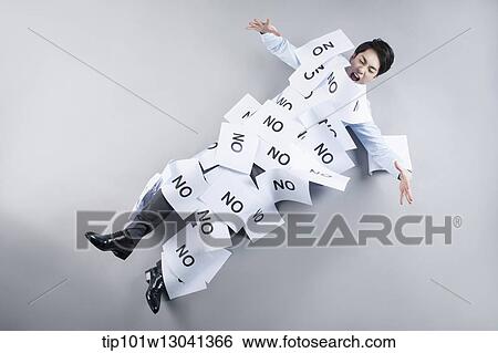 Stock Photograph - a business man covered by papers that say no. Fotosearch
