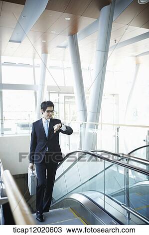 Stock Image - a business man going up the stairs. Fotosearch