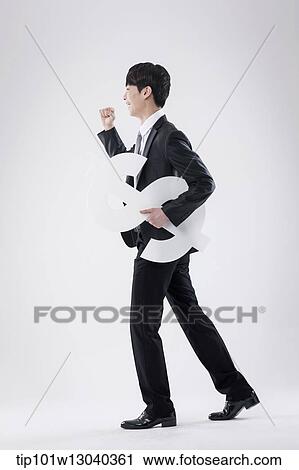 Stock Image - a business man holding a dollar sign. Fotosearch