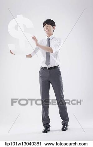 Stock Image - a business man holding a dollar sign. Fotosearch