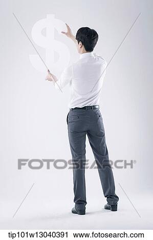 Stock Image - a business man holding a dollar sign. Fotosearch