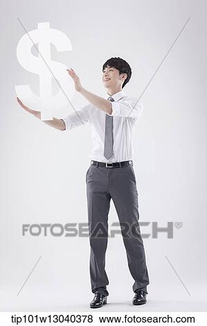 a business man holding a dollar sign View Large Photo Image Stock Photo - a business man holding a dollar sign. Fotosearch