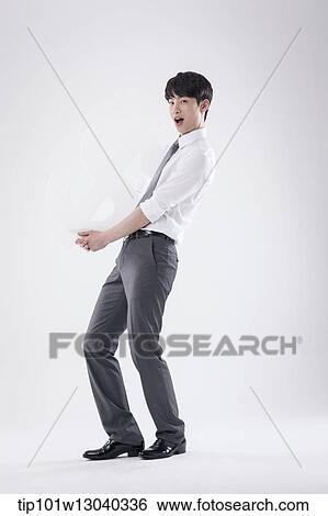 Stock Photograph - a business man holding a dollar sign. Fotosearch