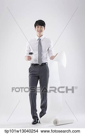 Picture - a business man holding a paper roll. Fotosearch