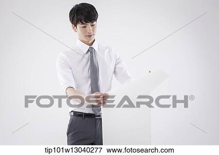 Stock Photo - a business man holding a paper roll. Fotosearch