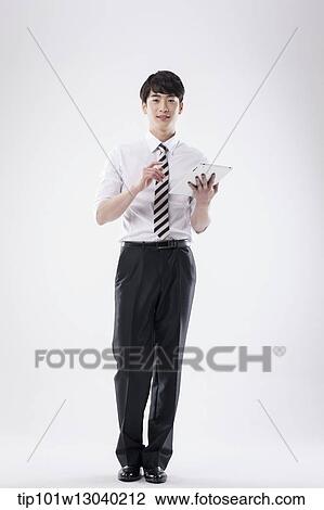 Stock Image - a business man holding a tablet. Fotosearch