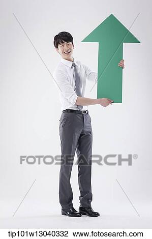 Stock Image - a business man holding an arrow. Fotosearch
