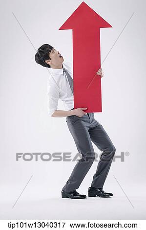 Stock Photo - a business man holding an arrow. Fotosearch