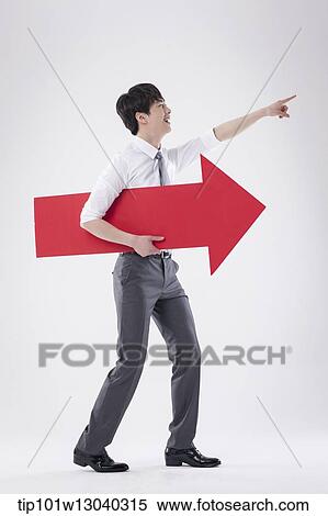 Stock Photography - a business man holding an arrow. Fotosearch