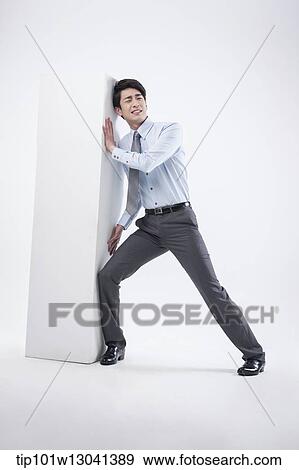 Stock Photo - a business man leaning at a block. Fotosearch