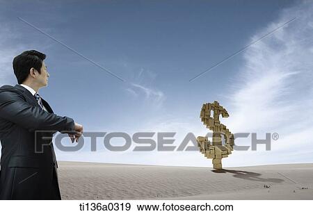 a business man looking at a dollar sign View Large Photo Image Stock Photo - a business man looking at a dollar sign. Fotosearch