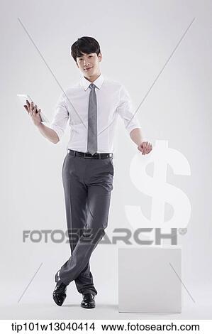 Picture - a business man next to a dollar sign. Fotosearch