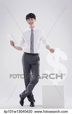 a business man next to a dollar sign View Large Photo Image Stock Image - a business man next to a dollar sign. Fotosearch
