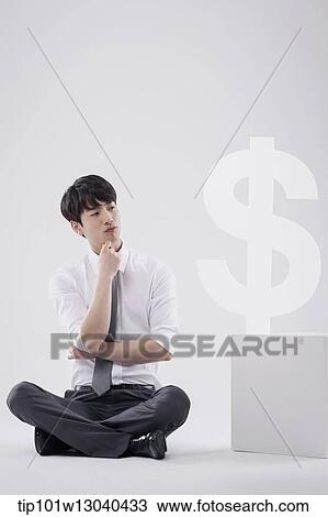 Stock Image - a business man next to a dollar sign. Fotosearch