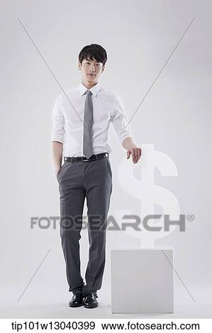 a business man next to a dollar sign View Large Photo Image Stock Photo - a business man next to a dollar sign. Fotosearch