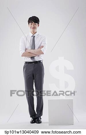 Stock Photo - a business man next to a dollar sign. Fotosearch