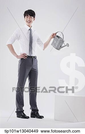 a business man next to a dollar sign View Large Photo Image Stock Photo - a business man next to a dollar sign. Fotosearch