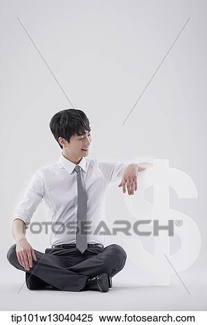 a business man next to a dollar sign View Large Photo Image Stock Photography - a business man next to a dollar sign. Fotosearch