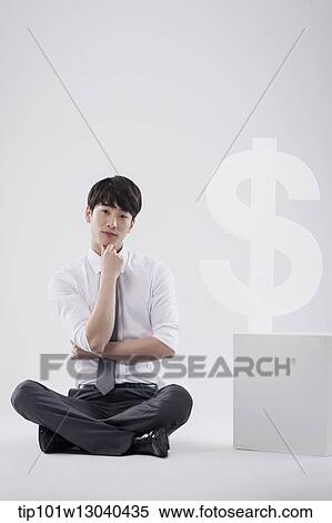 Stock Photography - a business man next to a dollar sign. Fotosearch