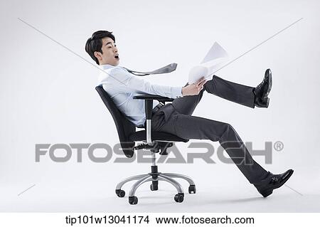 Picture - a business man playing with a chair. Fotosearch
