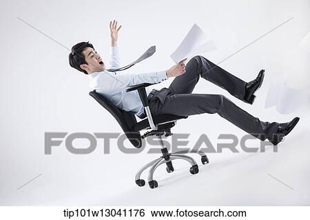 Stock Photograph - a business man playing with a chair. Fotosearch