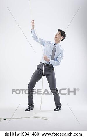 Stock Image - a business man pulling a wire. Fotosearch